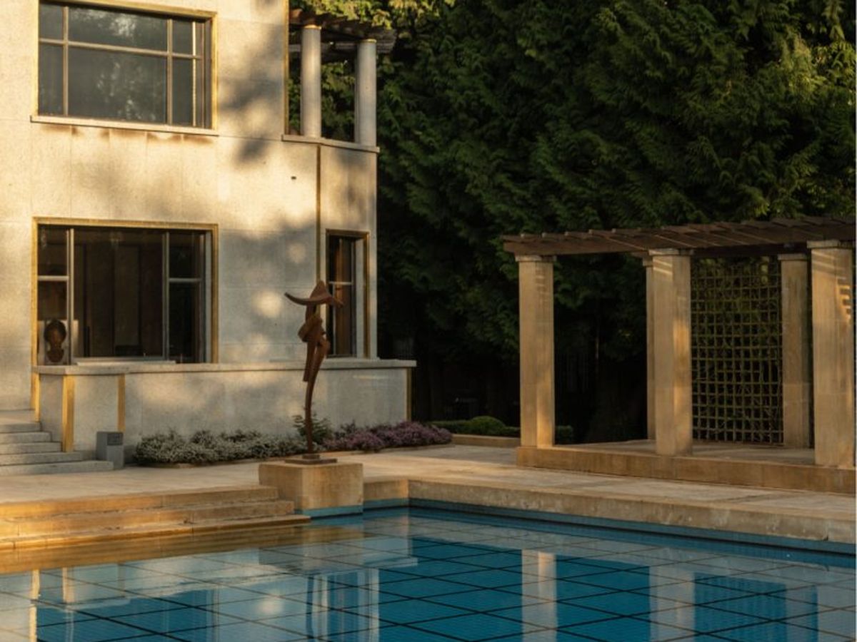 The garden and swimming pool of the Villa Empain at dusk
